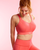 Woman wearing a Panache Endurance sports bra and leggings in Grapefruit colour front view